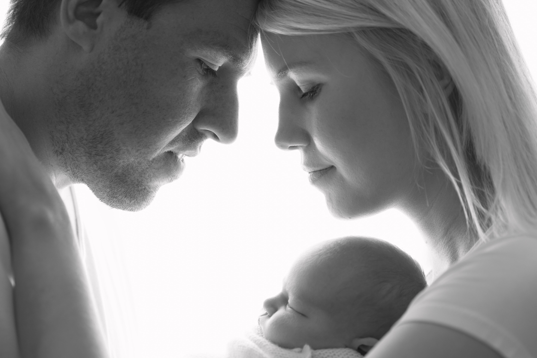 backlit black and white photo of new mum, dad and their baby by hayley morris photography specialist newborn photographer malvern worcestershire 
